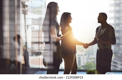 Lets Move Business Forward Together. Cropped Shot Of Businesspeople Shaking Hands In An Office.