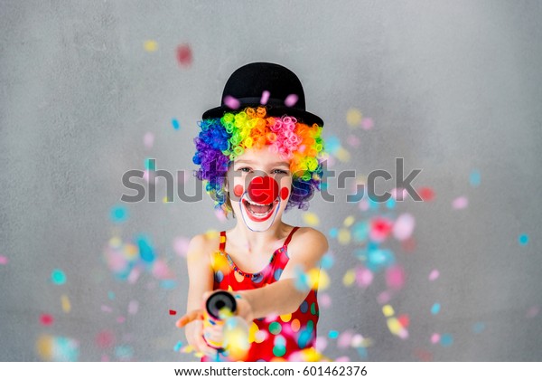 Давай вечеринка!! Забавный малыш клоун играет дома. Ребенок съемки партии поппер конфетти. 1 апреля Дурак день концепции
