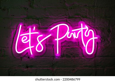 Lets party pink glowing neon sign banner on brick wall - Powered by Shutterstock