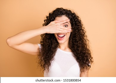 Let's Play Game! Photo Of Pretty Funny Lady Hiding Eye Half Playful Facial Expression Fingers Wear White Casual Clothes Isolated Beige Pastel Color Background