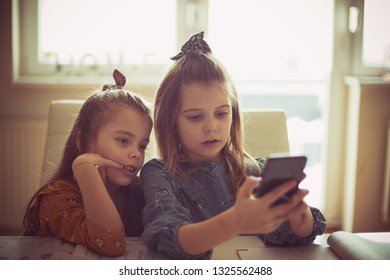  Let's See What's On You Tube, Two Little School Girls Using Smart Phone. Copy Space.