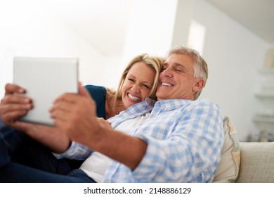 Lets Show The World What Love Looks Like. Cropped Shot Of A Mature Couple Taking A Selfie On A Digital Tablet At Home.