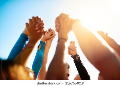 Lets stand together. Shot of a group of unrecognizable people holding hands together in the air. - Powered by Shutterstock