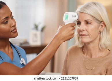 Lets start your physical but first a fever check. Shot of a doctor examining a mature woman with a thermometer at home.
