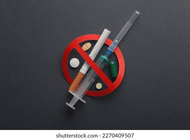 Detengamos la adicción a las drogas. Jeringas y cigarrillos, pastillas con signo de prohibición en el fondo oscuro
