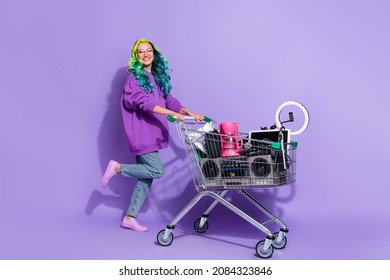 Let's swap. Vivid haired lady youth pull trolley with old stuff sell garage sale isolated over violet color background