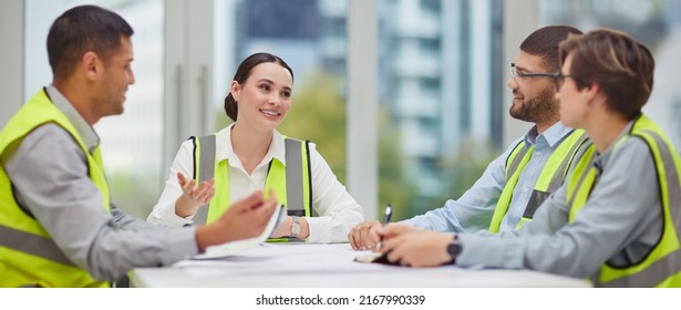 Lets Talk Construction. Cropped Shot Of A Group Of Young Construction Workers Sitting Around The Boardroom Table During A Meeting.