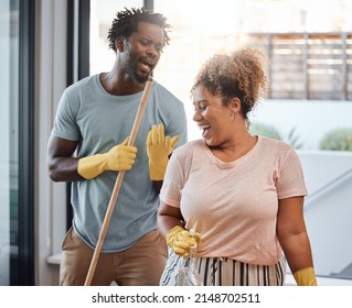 Lets Turn Chores Into Something Fun. Shot Of A Young Couple Singing While Cleaning At Home.