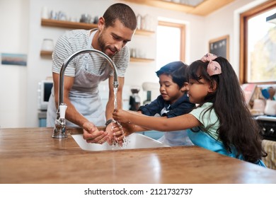 Let's wash those germs away. Cropped shot of a man and his two children washing their hands in the kitchen basin. - Powered by Shutterstock