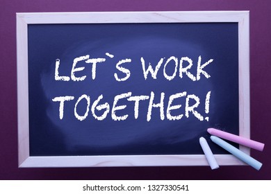 Let's work together message on the blackboard and color chalks. Business concept