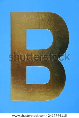 Letter B uppercase - golden color font on blue background, Close up