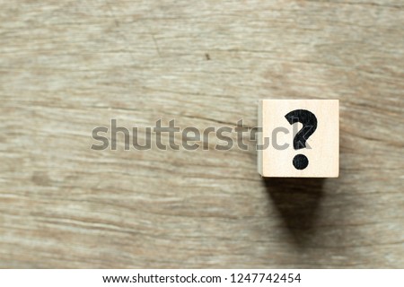 Letter block in question mark on wood background