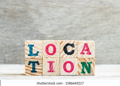 Letter Block In Word Location On Wood Background