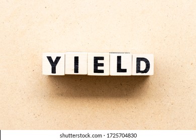 Letter block in word yield on wood background
