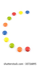 Letter C Made Of Colored Smarties, Isolated Over White