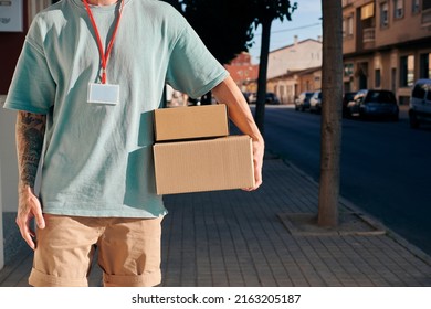 Letter Carrier Holding Some Cardboard Boxes During Mail Delivery