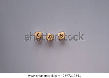 Letter cubes forming the word “Fun” on a bright background, symbol of joy and lightheartedness.