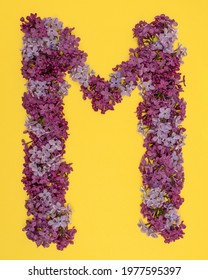 The letter M is lined with lilac flowers on a yellow background. For lettering, composing words