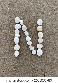 Letter N Made Of White Pebbles On The Sand