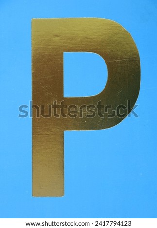 Letter P uppercase - golden color font on blue background, Close up