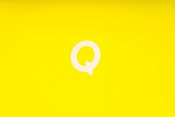 Letter Q In Wood On Yellow Background