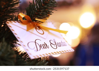 Letter for Santa Claus. A Christmas letter is hanging on the tree. An envelope with the inscription Dear Santa. - Powered by Shutterstock