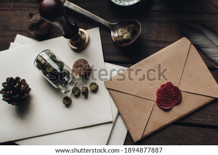 Letter seal with wax seal stamp on the wood table. Vintage notary stamp and sealed envelope. Post concept. Sealing wax. Wax seal. Dark academia style. Scandinavian hygge styled composition.
