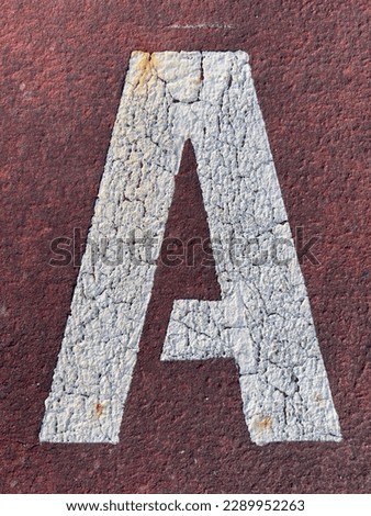 Letter A stenciled on the pavement.