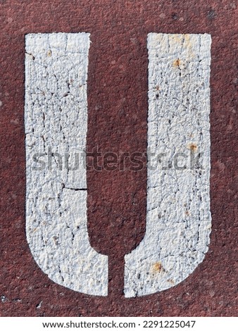Letter U stenciled on the pavement.