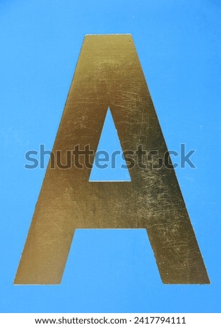 Letter A uppercase - golden color font on blue background, Close up