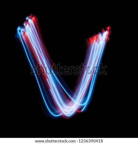Letter V of the alphabet made from neon sign. The blue light image, long exposure with colored fairy lights, against a black background
