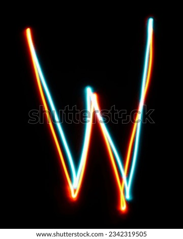 Letter W of the alphabet made from neon sign. The blue red light image, long exposure with colored fairy lights, against a black background. Concept of design