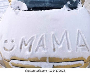 Lettering Mama With A Smile In The Snow On The Hood Of The Car.  Happy Mother's Day, Love Mom Word