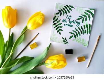 lettering-card "let the spring come" with yellow tulips bouquet, watercolor and brushes on white background