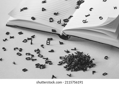 Letters Of The Alphabet Fall Out Of The Notebook, Black And White Shot, Concept Or Idea Of ​​a New Book, Article, Copyright