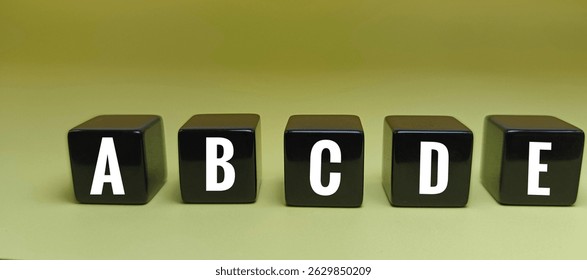 Letters A B C D E on Black Dice – Educational Alphabet Concept Representing Basic Literacy, Language Learning, Typography, and Communication Symbols. 