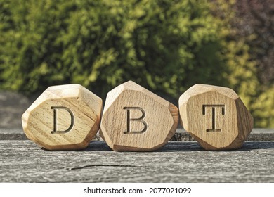 Letters DBT written on wooden blocks. Dialectical Behavior Therapy psychological treatment concept.