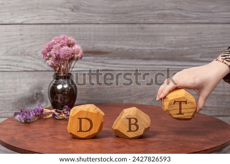 Letters DBT written on wooden blocks. Dialectical Behavior Therapy psychological treatment concept.