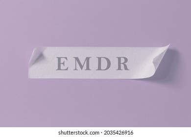 Letters EMDR written on piece of masking tape stuck to purple background. Eye Movement Desensitization and Reprocessing psychotherapy treatment concept. - Shutterstock ID 2035426916