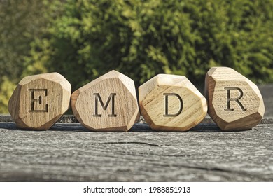 Letters EMDR written on wooden irregular blocks. Eye Movement Desensitization and Reprocessing psychotherapy treatment concept. - Shutterstock ID 1988851913