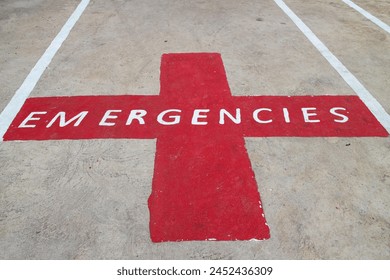 The letters EMERGENCIES on a red cross symbol. It was painted on the road as an emergency parking area. - Powered by Shutterstock