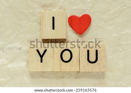 Letters spelling I love you. Red heart and Wooden letters spelling I love you