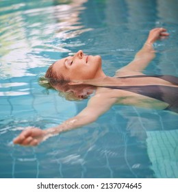 Letting her stress float away. Cropped shot of a mature woman relaxing in an indoor swimming pool. - Powered by Shutterstock