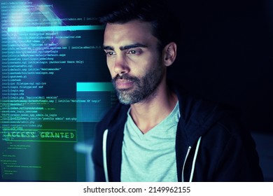 Letting himself get lost in the code. Shot of a focussed computer hacker using a computer in the dark.