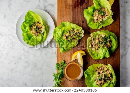 Lettuce wraps. Japanese or Thai cuisine entree favorites. Lettuce wraps made with noodles, pork, chicken, tofu, scallions, cilantro, sprouts, eggs, limes, jalapeños, peanut and sauce.. Japa