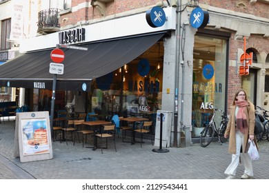 Leuven, Flemish Brabant, Belgium - February 23, 2022: Young Defocussed Blond Lady In Front Of Leuven Wasbar. An Indoor Gathering Place While The Washing Machine Is Washing Customers Clothes They Can H