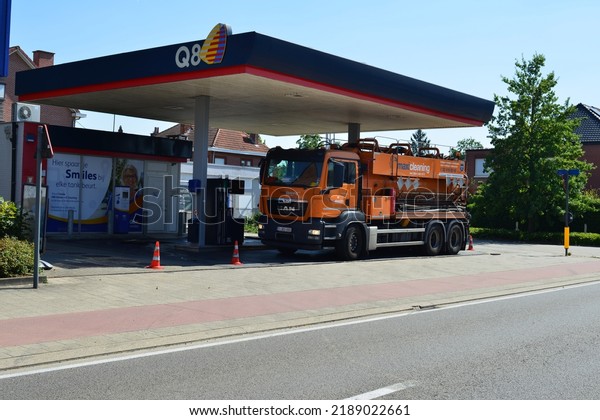 Leuven, Vlaams-Brabant, Belgium August 11, 2022: orange\
colored truck Maxi cleaning and unblocking pipes service is\
stationary under the awning of petrol station Q8 Kuwait Petroleum\
International 