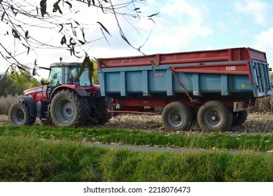 Leuven, Vlaams-Brabant, Belgium - October, 24, 2022: Tractor Fergusson 6480 With Wheeled Trailer Waiting For  Cutting Ripe Corn From The Field On A Cloudy Sunny Weather.