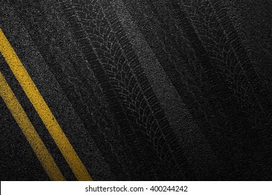 Level asphalted road with a dividing yellow stripes and tyre tracks. The texture of the tarmac, top view. - Shutterstock ID 400244242