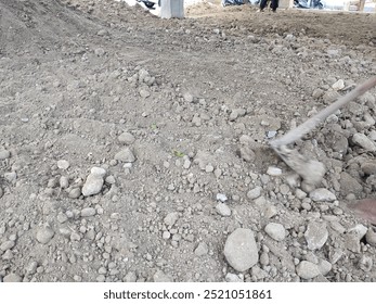 level the ground using a hoe for the base layer of the house floor.